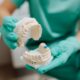 Gloved hands holding upper and lower plaster dental casts